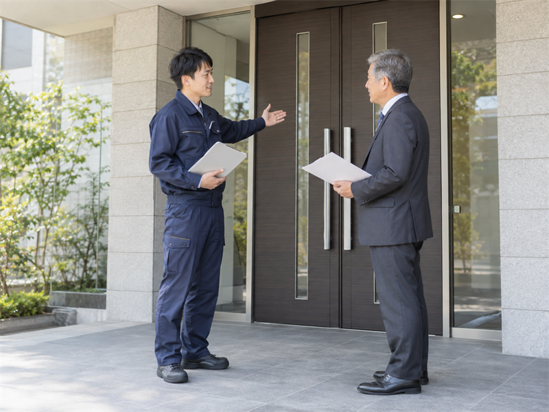 管理会社担当者に説明するスタッフ